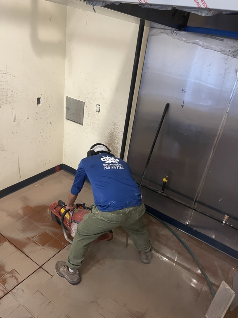 ESM Construction crew member cutting the floor for underground plumbing
